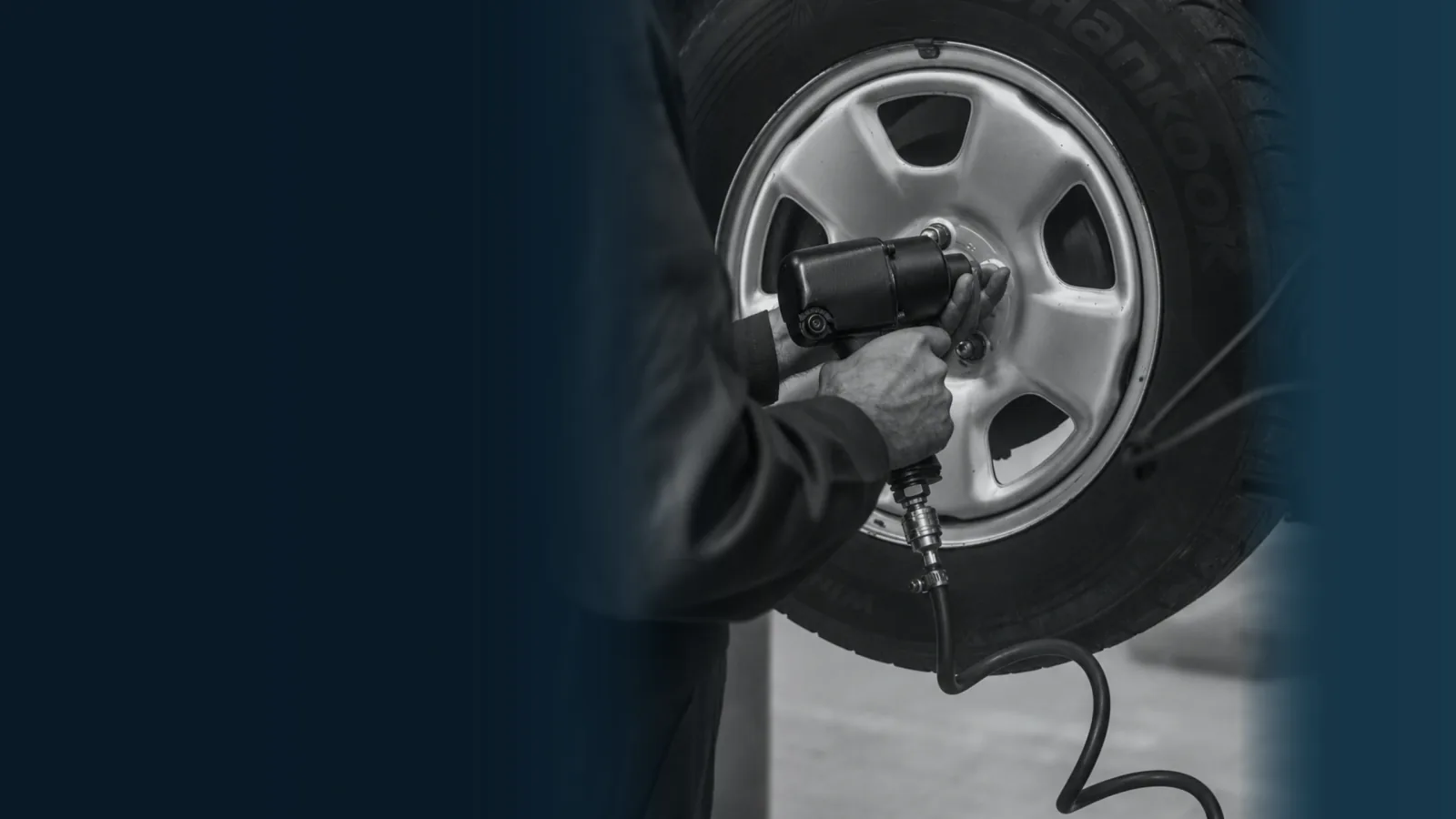 Illustrative wheel-service scene with a mechanic at a wheel